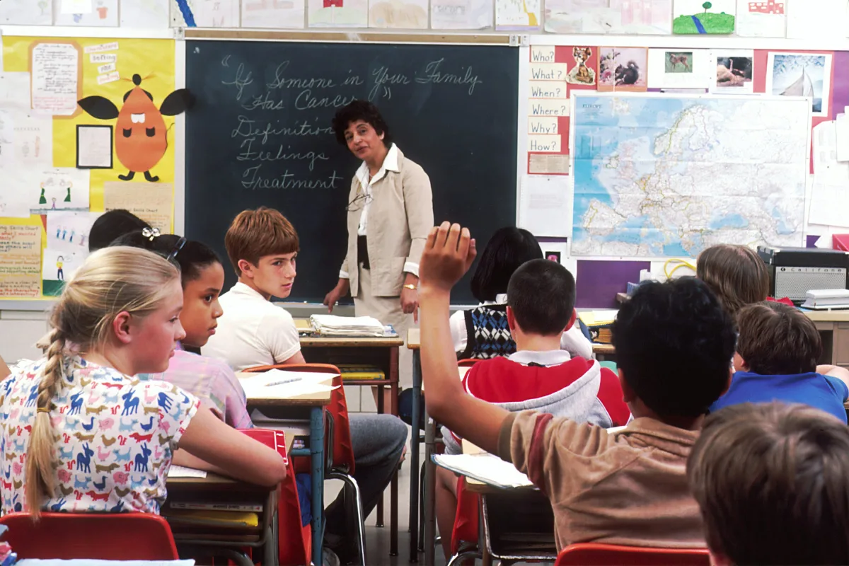 Salle de classe avec des enfants attentifs autour d'une enseignante, illustrant la scolarisation des enfants d'expatriés
