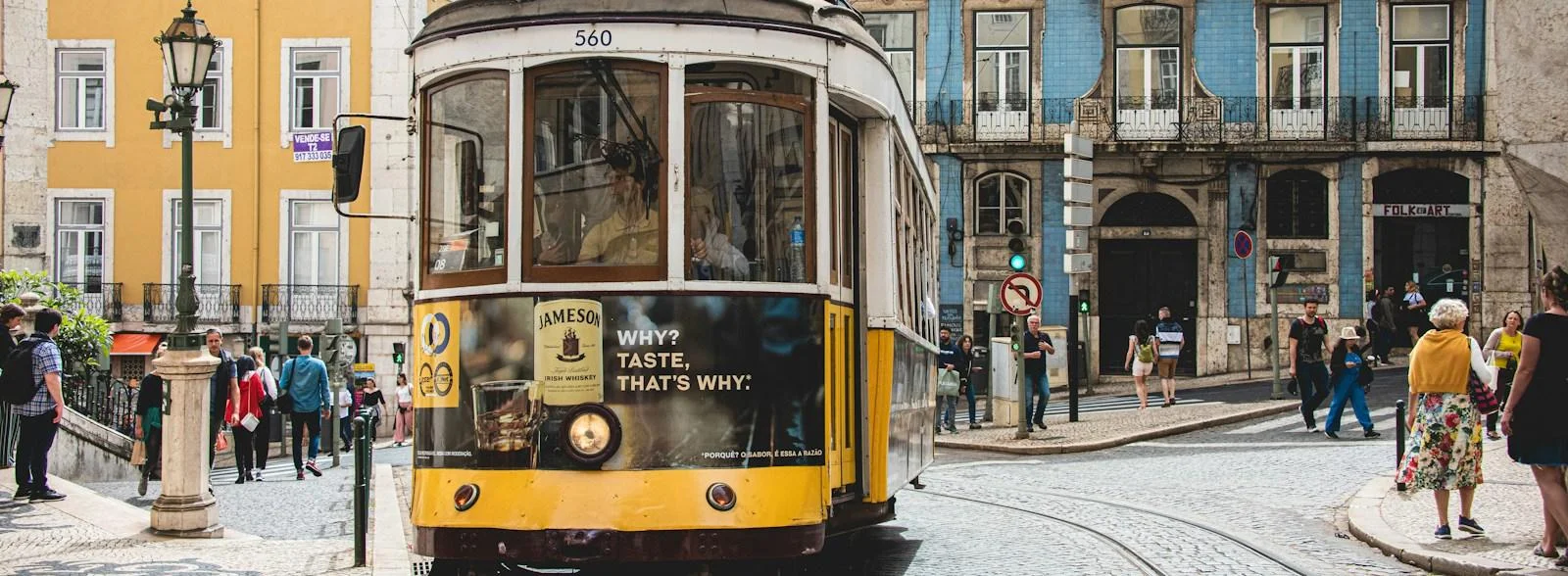 Tram jaune emblématique dans une rue animée de Lisbonne, Portugal